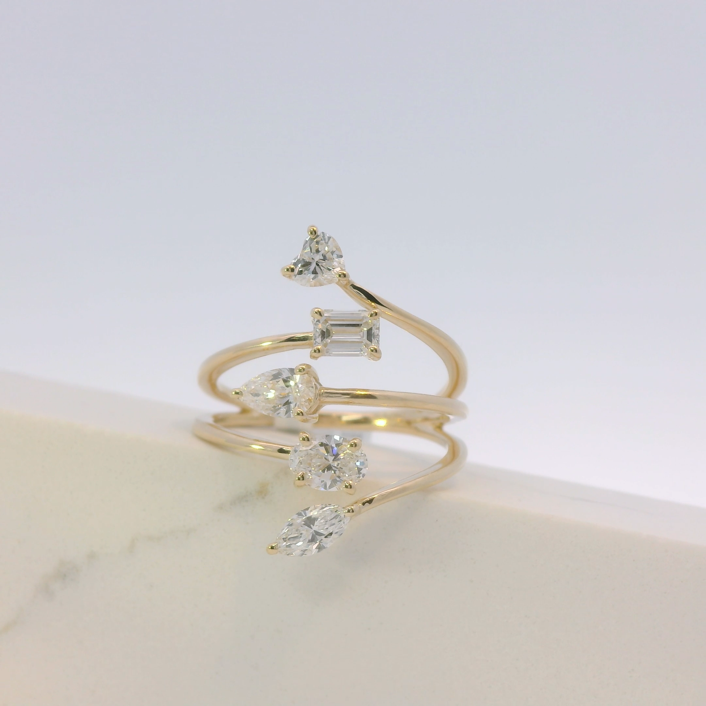 Gold ring with multiple diamond stones on a light background