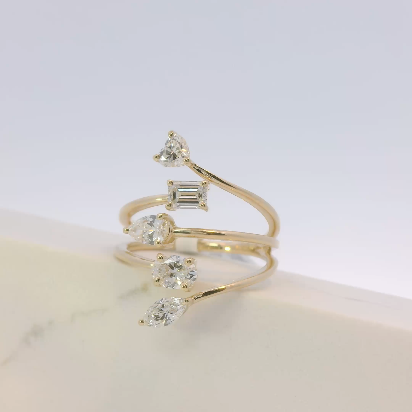 Gold ring with multiple gemstones on a light background