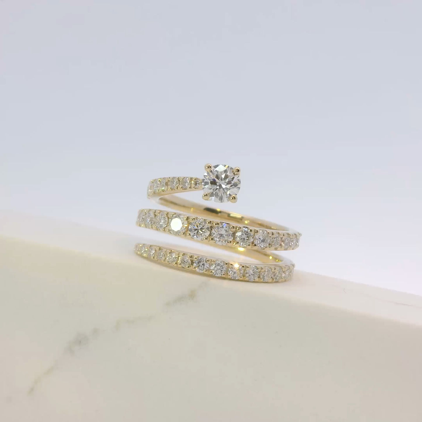 Gold ring with diamond on a light gray background