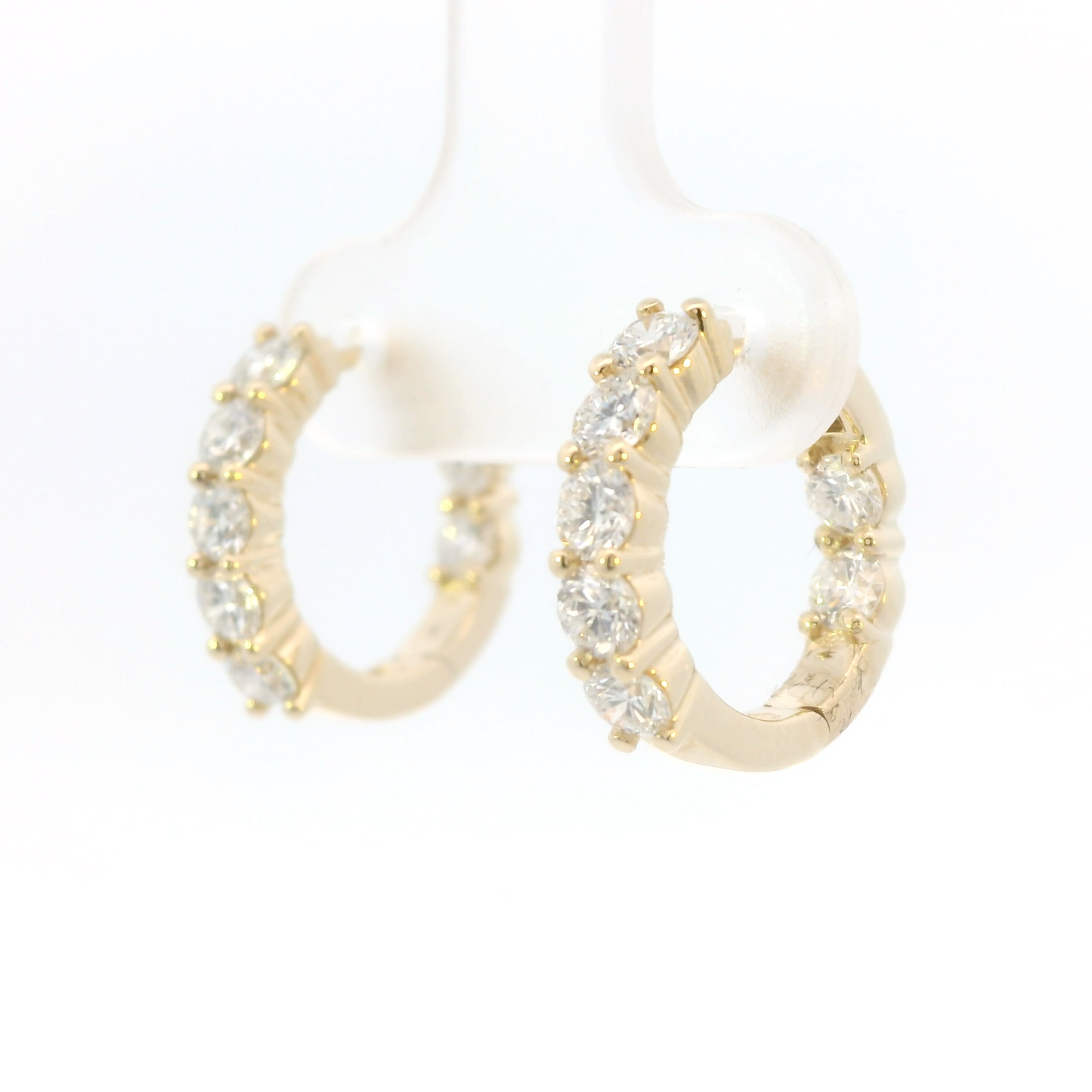 Gold hoop earrings with diamonds on a white background