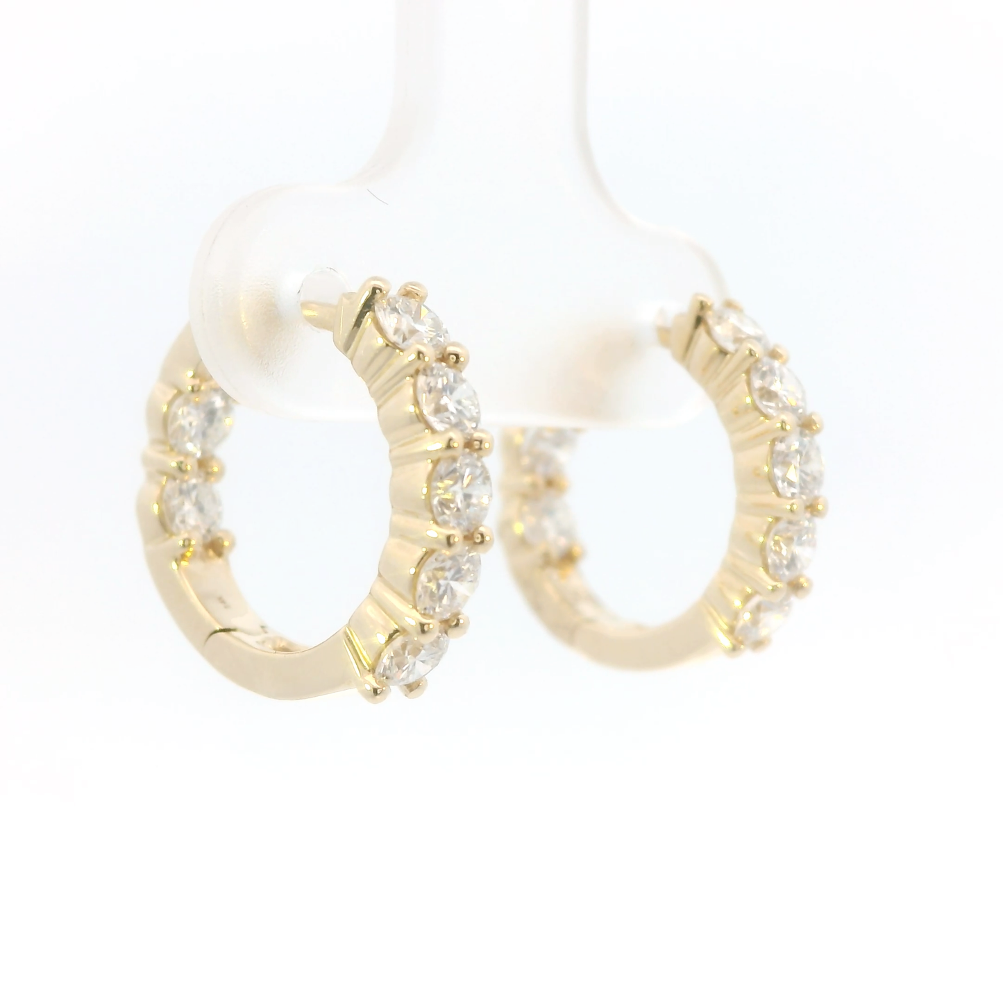 Gold hoop earrings with clear gemstones on a white background