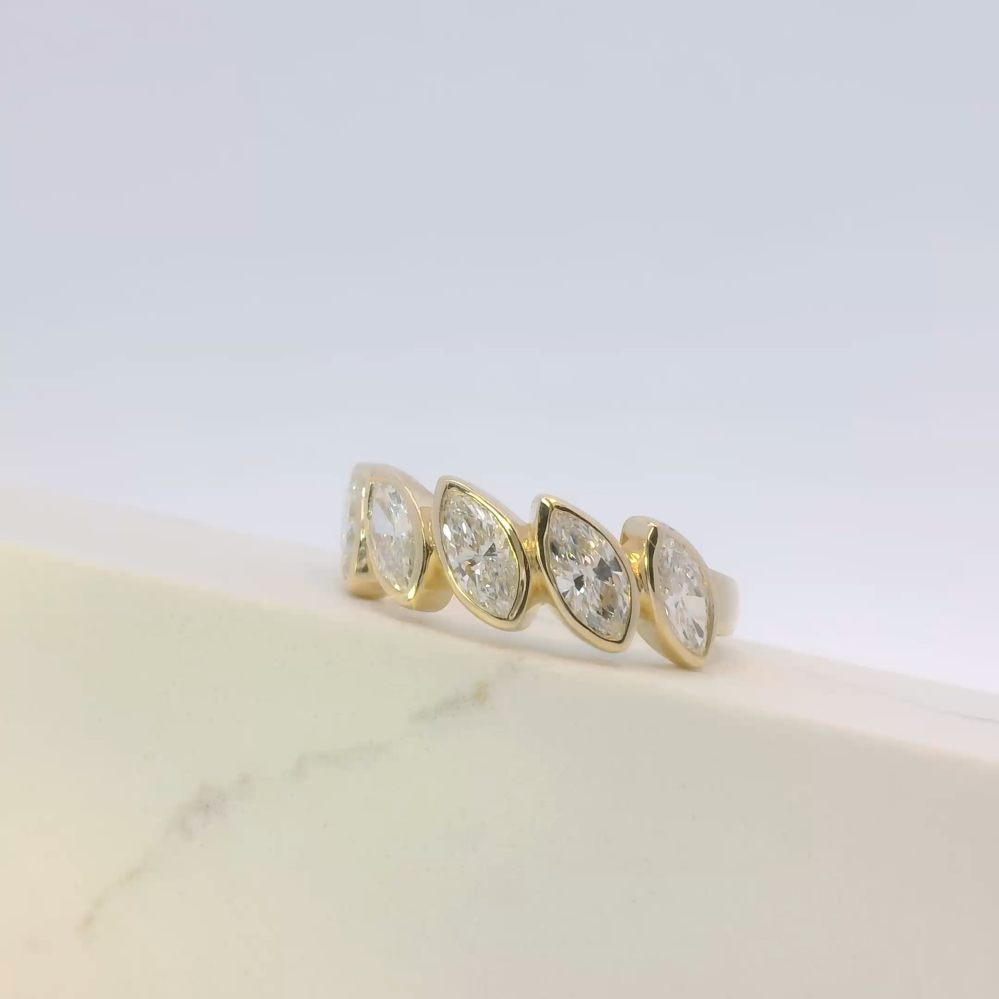 Gold ring with three clear gemstones on a light background
