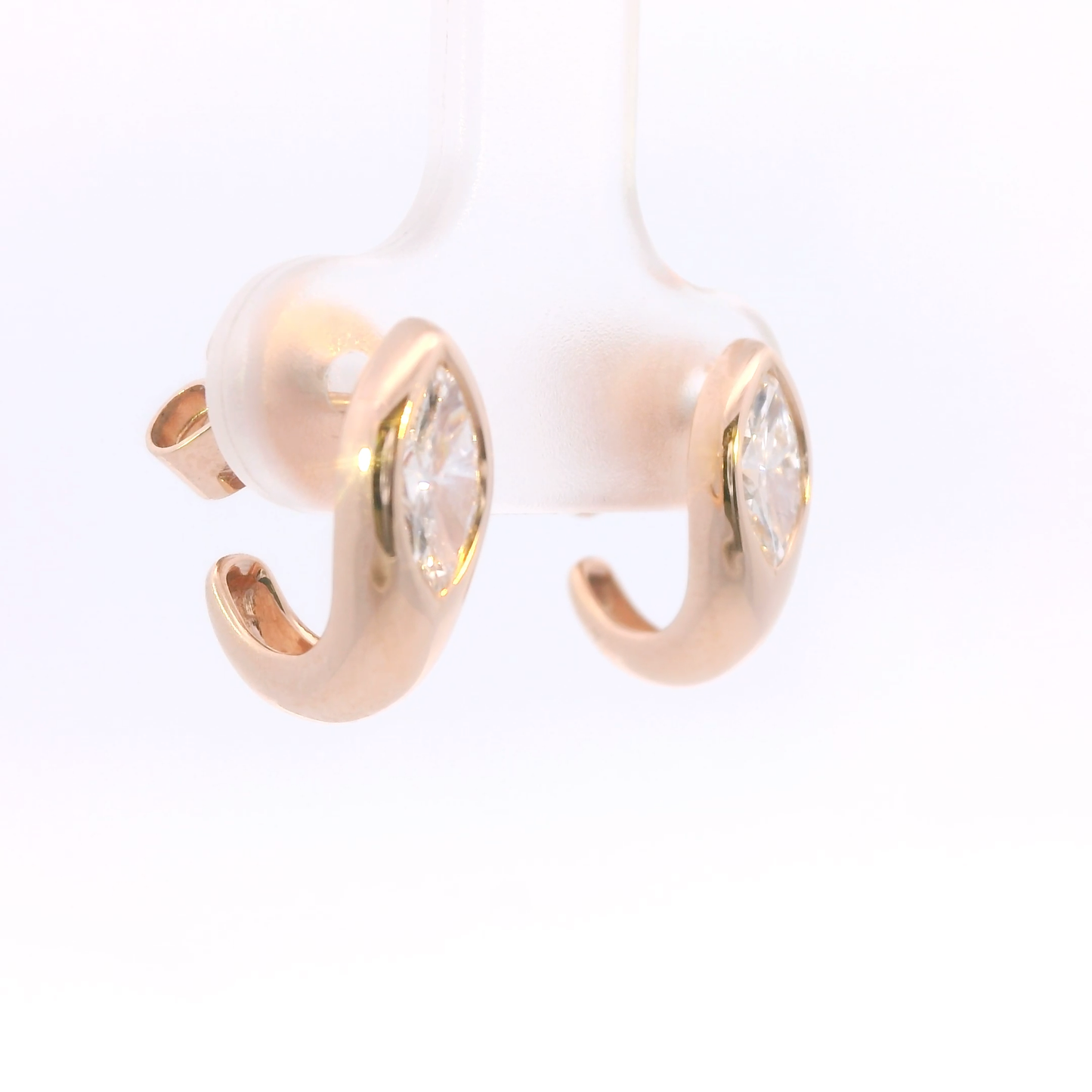 Rose gold hoop earrings with clear gemstones on a white background