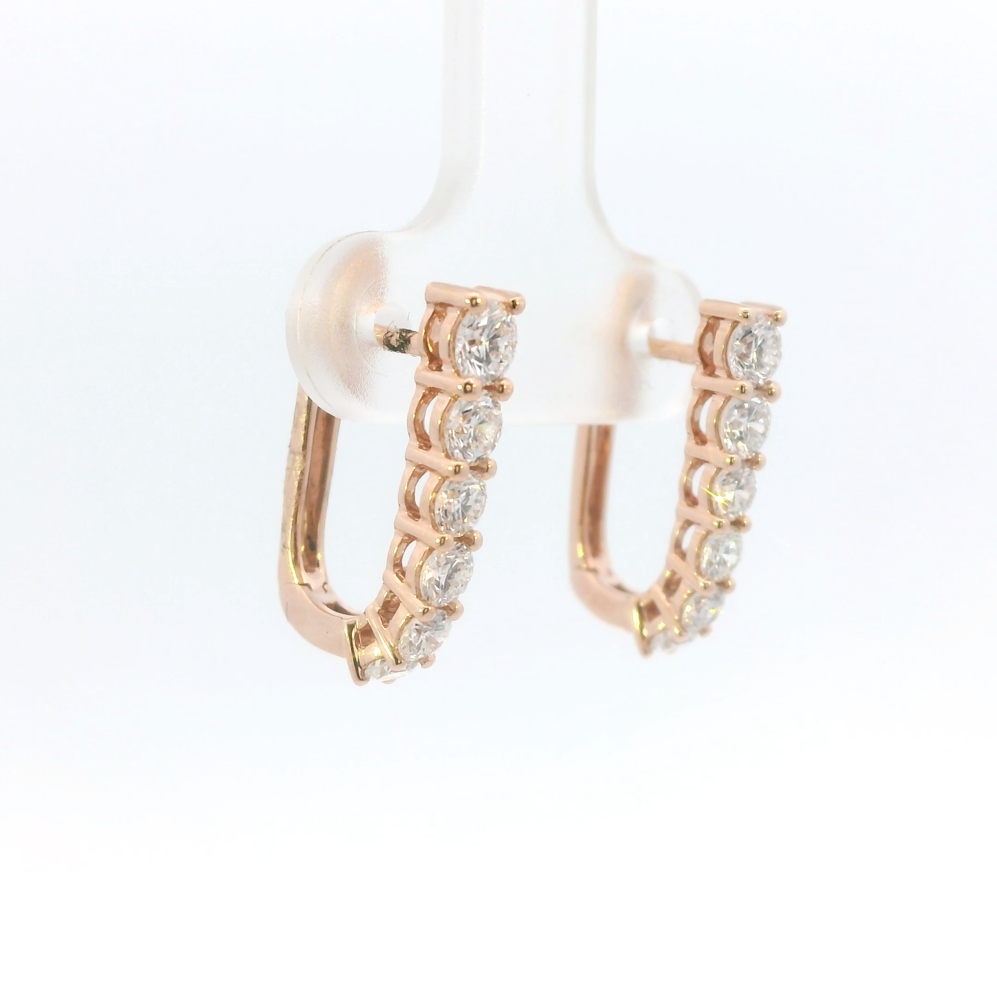 Rose gold hoop earrings with clear gemstones on a white background