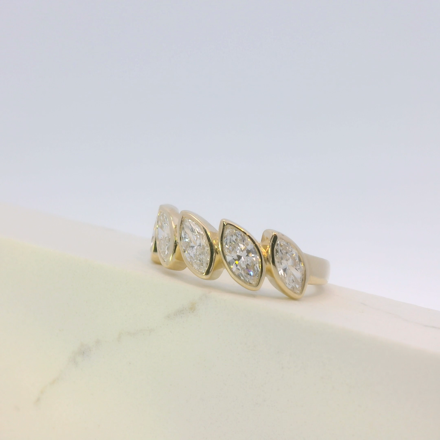 Gold ring with three diamonds on a light background