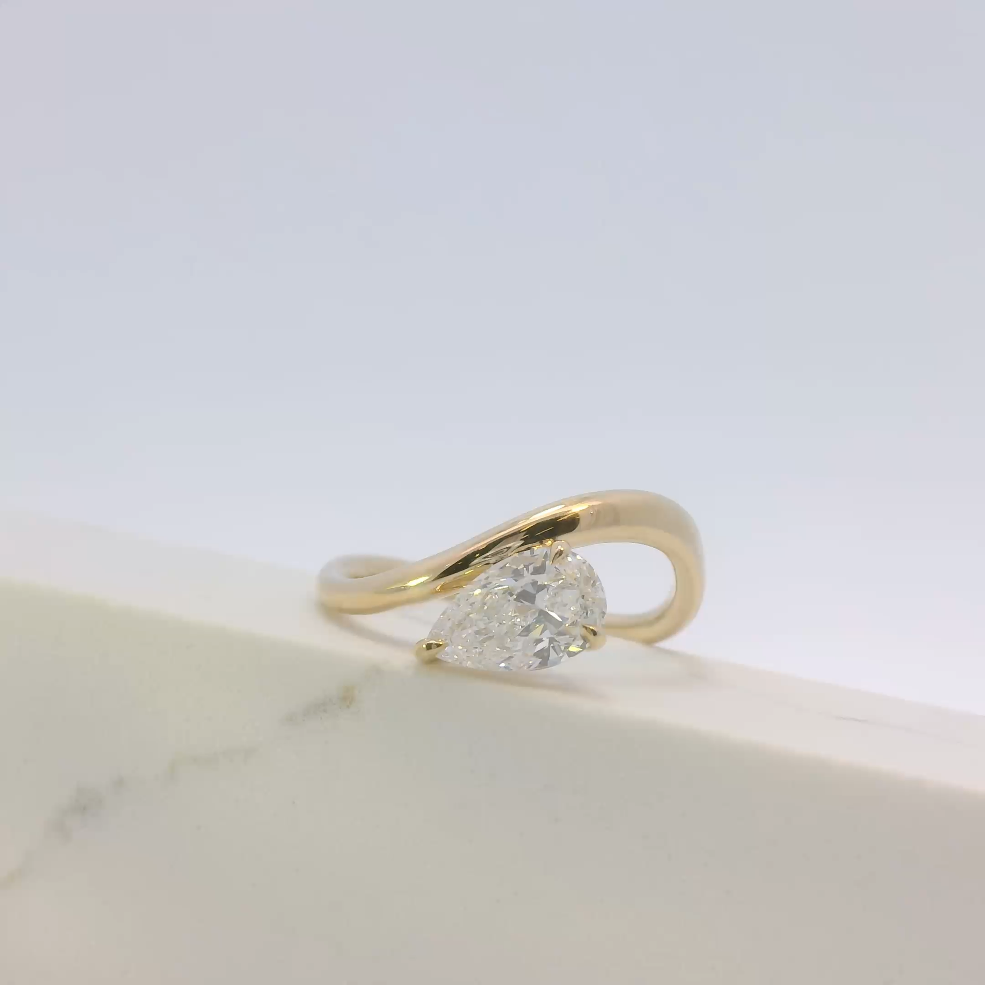 Gold ring with a diamond on a light background