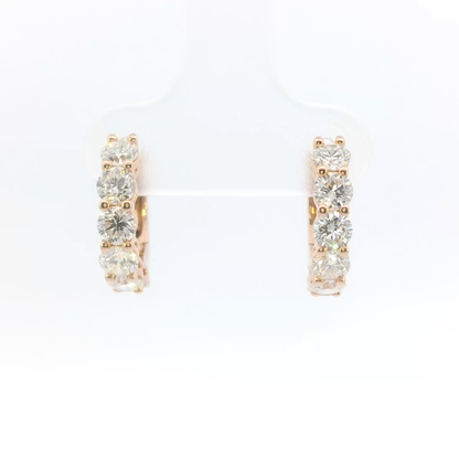 Pair of rose gold hoop earrings with clear gemstones on a white background