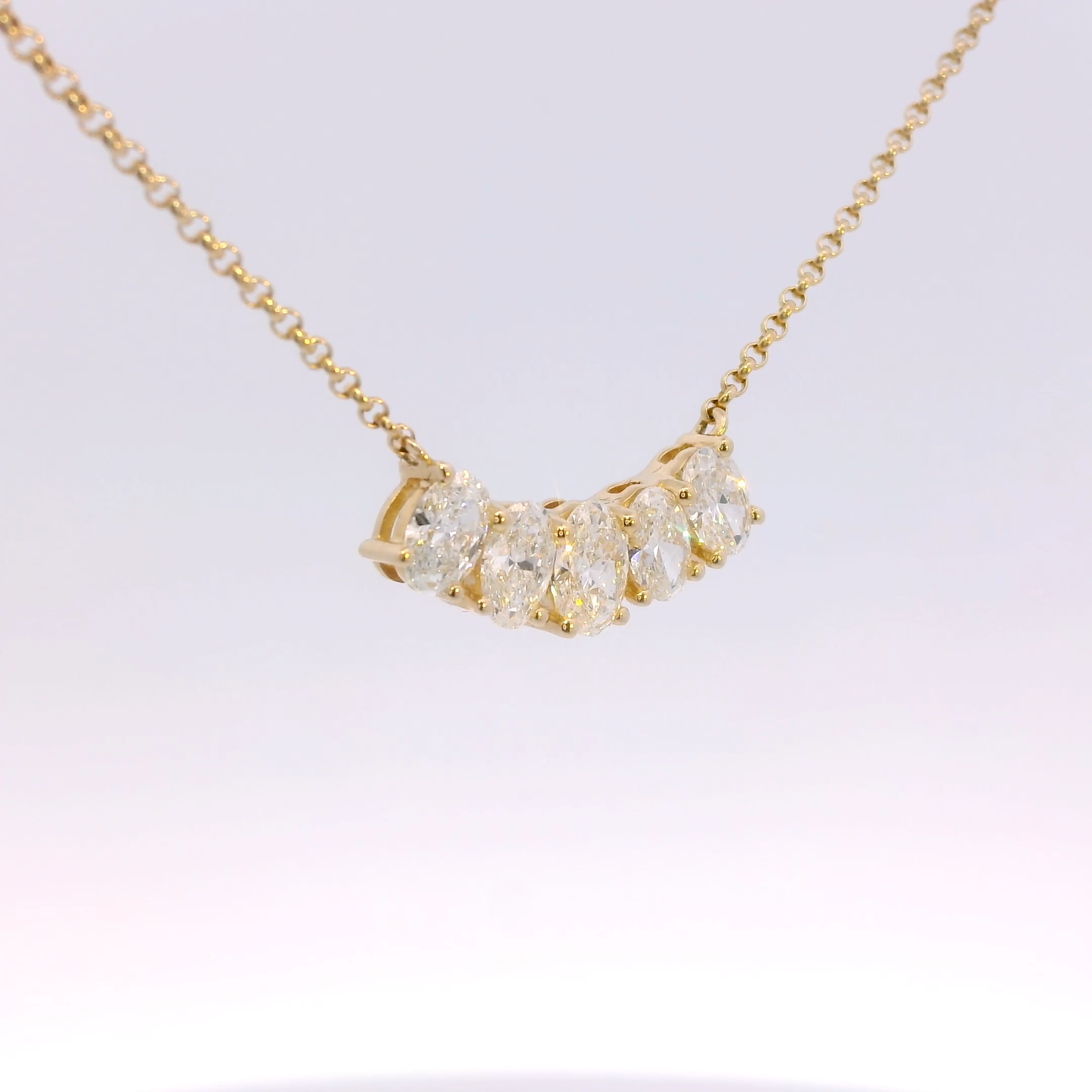 Gold necklace with diamond pendants on a white background
