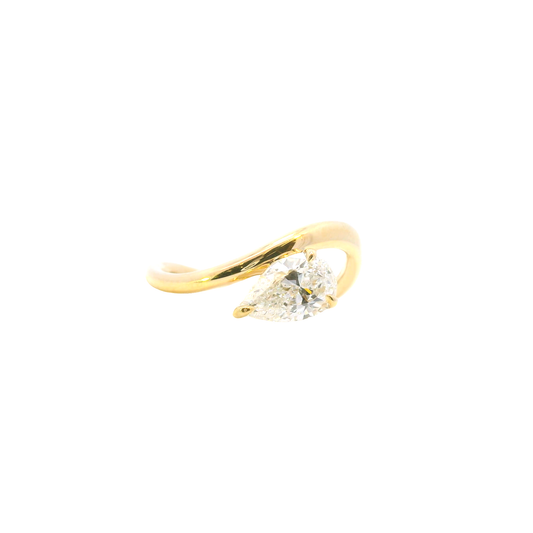Gold ring with a pear-shaped diamond on a white background