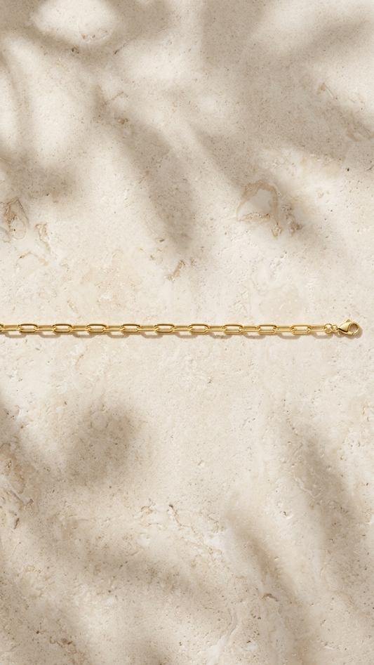 Elowen 9k yellow gold paperclip bracelet, styled flat lay, Luma Jewellery