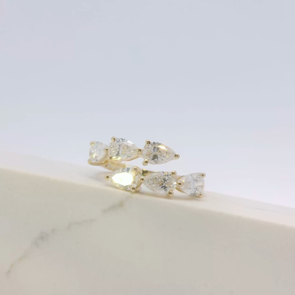 Gold earrings with clear gemstones on a light gray background