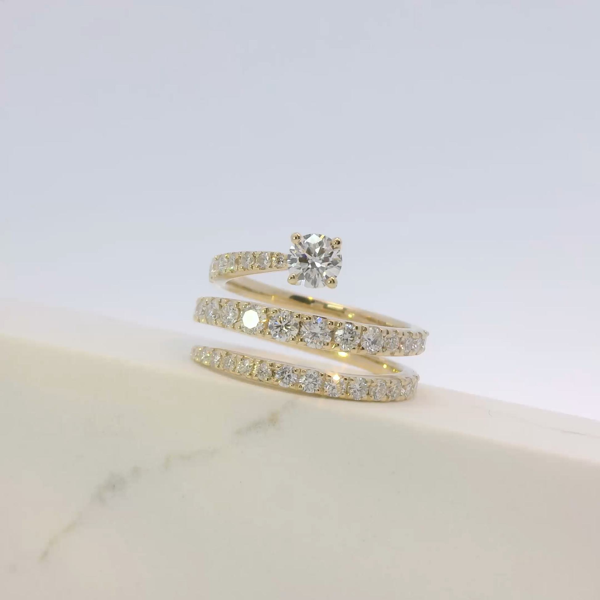 Gold ring with diamond on a light gray background