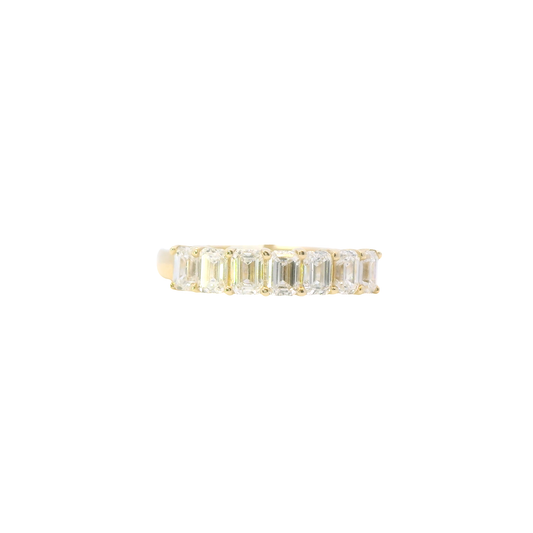 Gold ring with emerald-cut diamonds on a white background