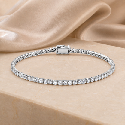 Isaline Fine Line 9k white gold lab grown diamond tennis bracelet on an ivory stone surface