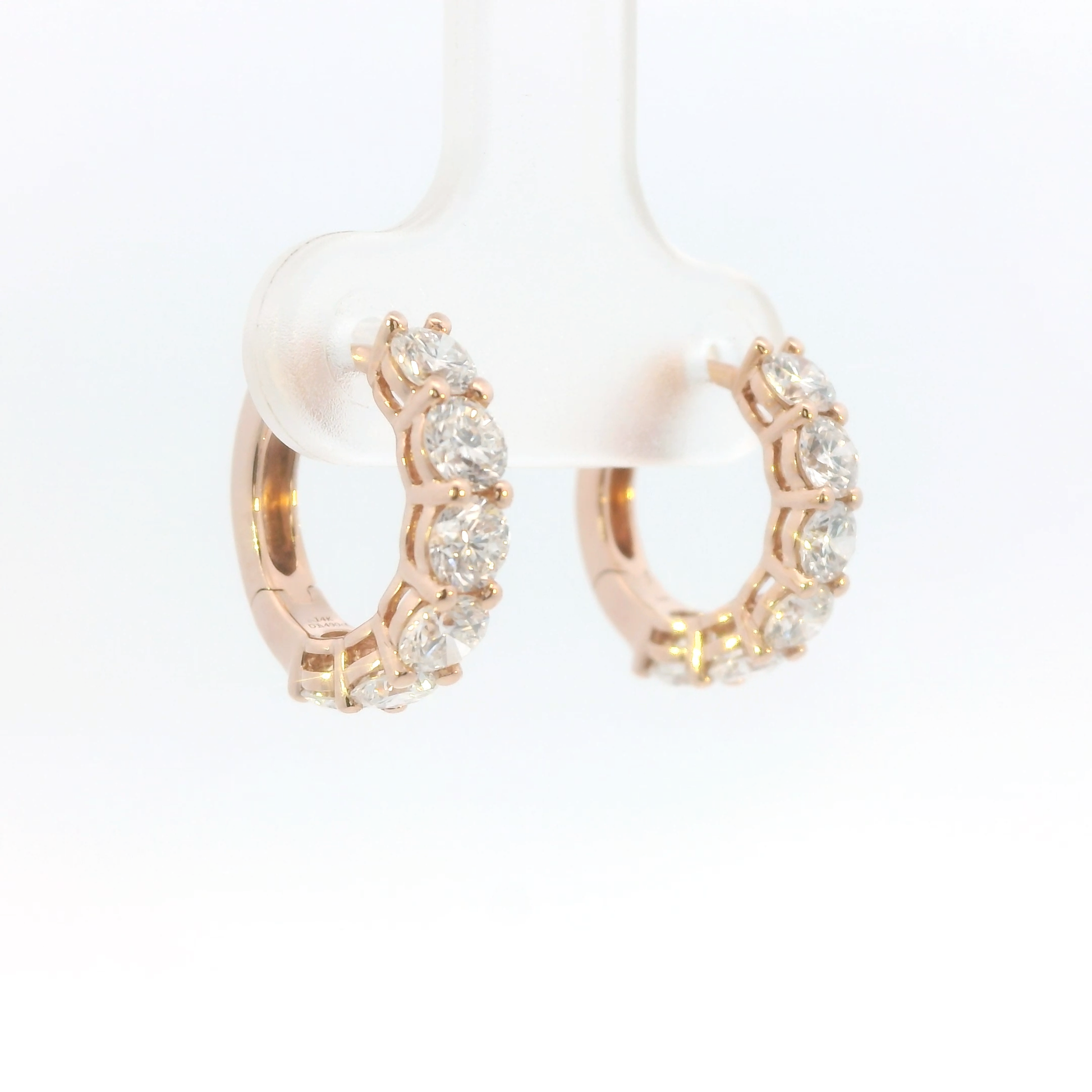 Rose gold hoop earrings with clear gemstones on a white background