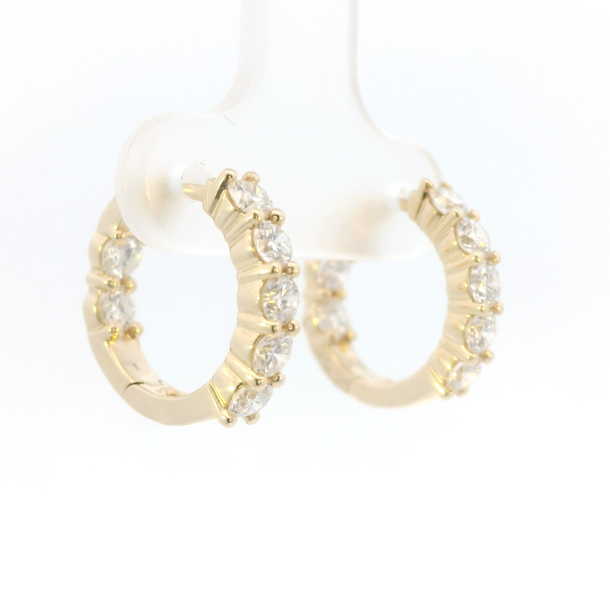 Gold hoop earrings with clear gemstones on a white background
