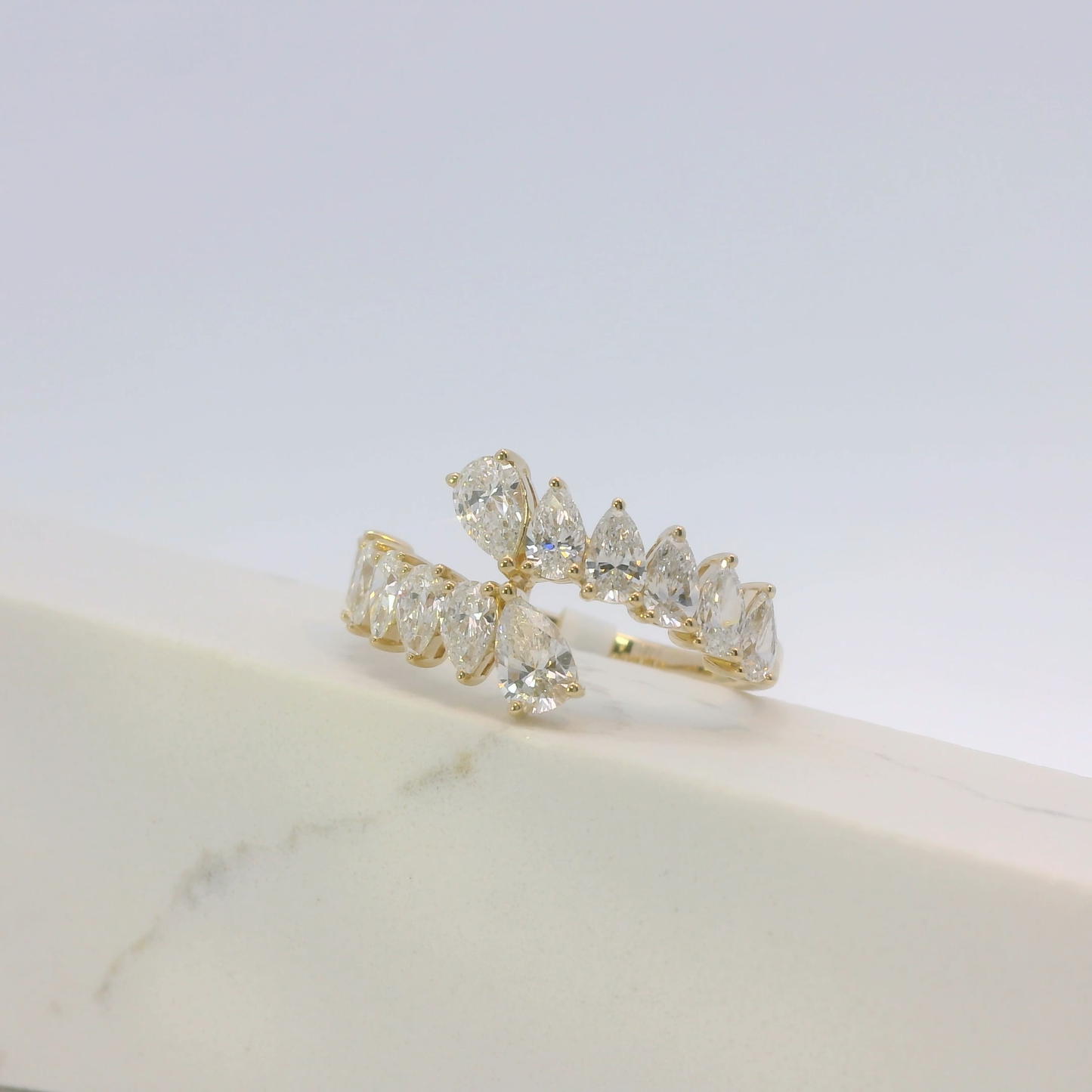 Gold ring with clear gemstones on a light background