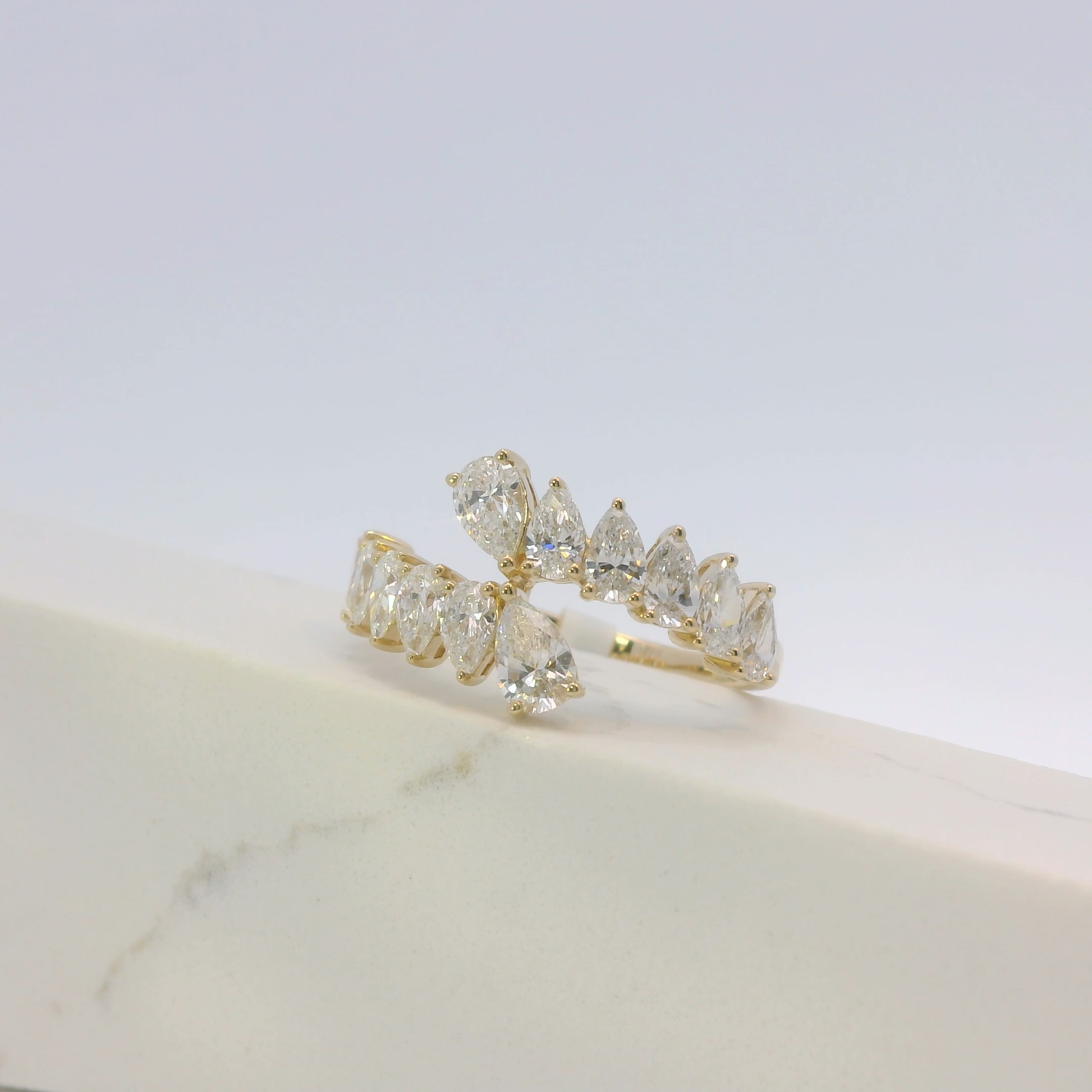 Gold ring with clear gemstones on a light background