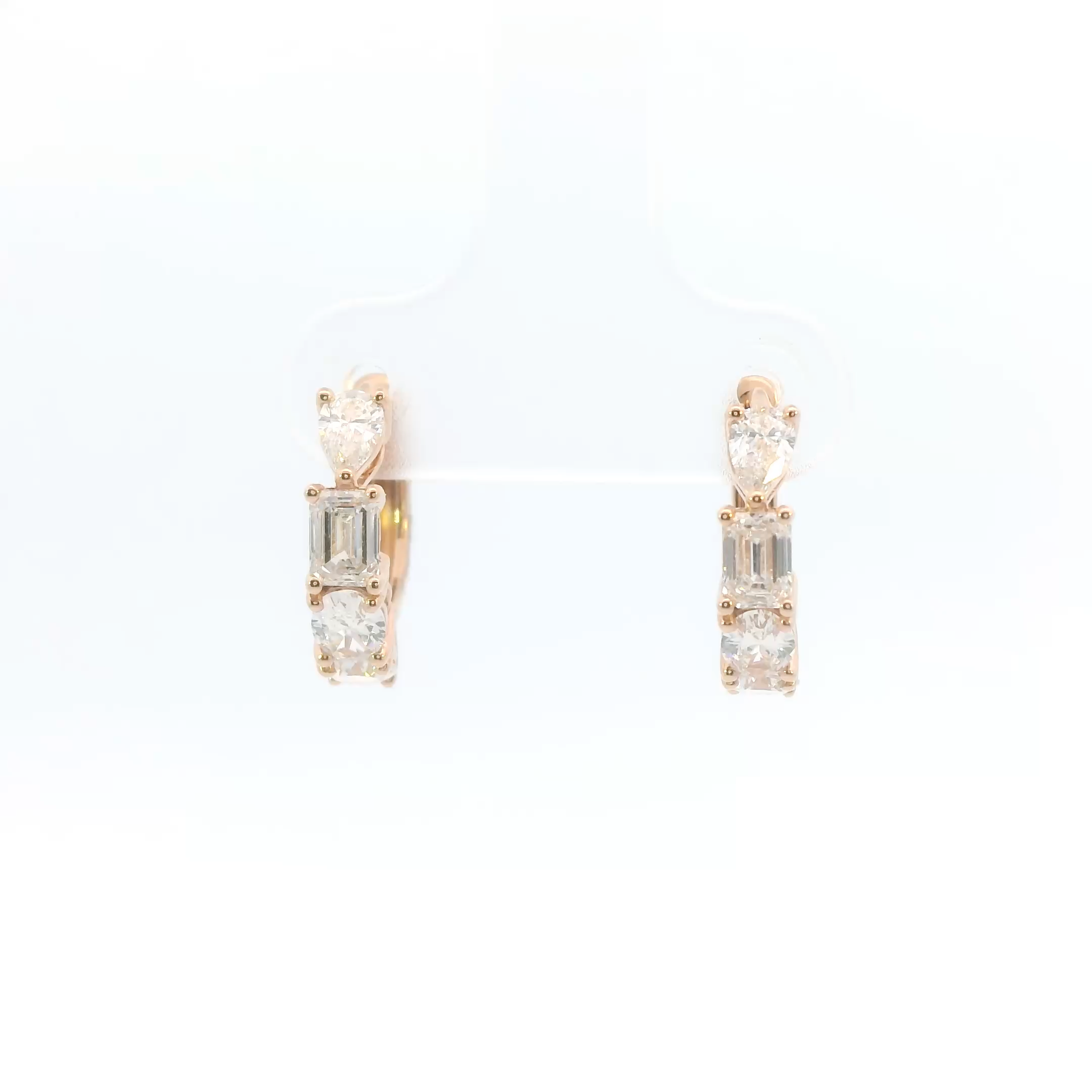 Pair of rose gold earrings with clear gemstones on a white background