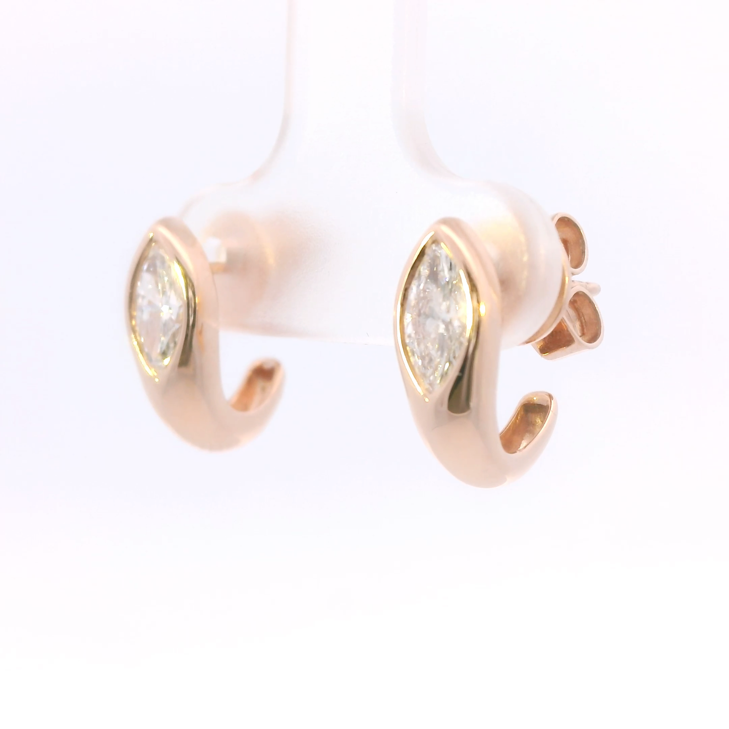 Rose gold hoop earrings with clear gemstones on a white background