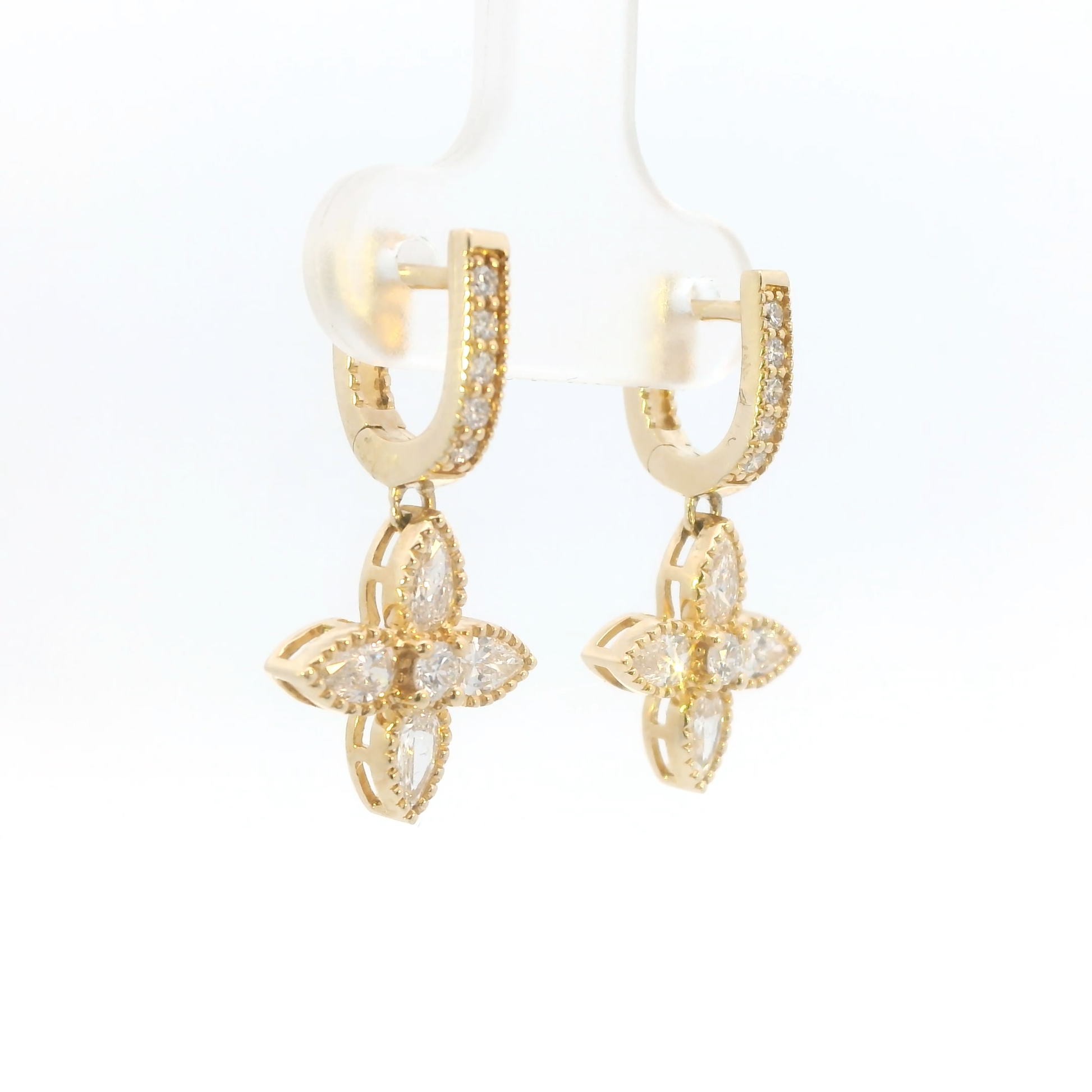 Gold earrings with floral designs on a white background