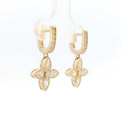 Gold earrings with floral designs on a white background